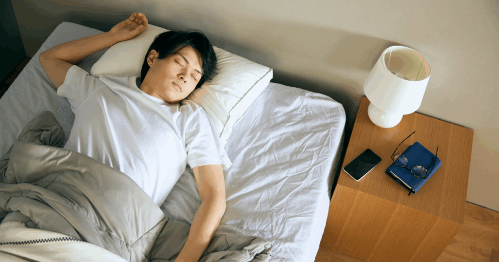 男性がスマホと離れて寝ている写真
